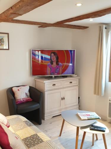 a living room with a flat screen tv on a white cabinet at Gîte, Maison indépendante "Chez Yvette et André" 2 à 6 pers, Ribeauvillé à 3 km, Colmar à 10 km in Guémar