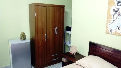 a bedroom with a wooden cabinet and a refrigerator at The Cottages by the Sea in San Clemente