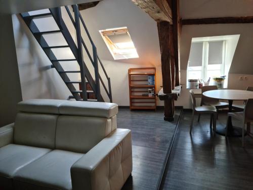 a living room with a staircase and a couch at Beaugency-3 sur la route des châteaux in Beaugency