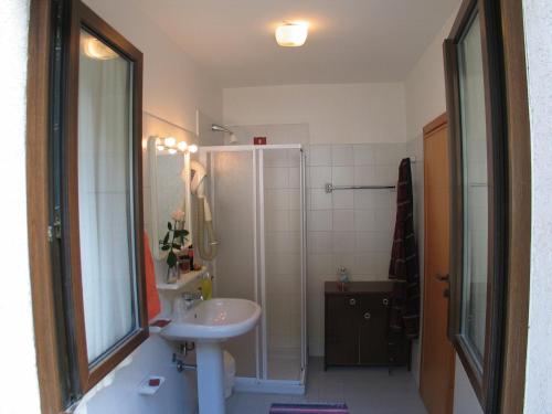 ein Badezimmer mit einem weißen Waschbecken und einer Dusche in der Unterkunft Hotel La Lanterna in Chiesa in Valmalenco