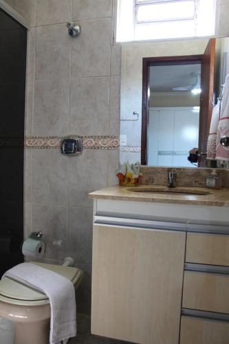 a bathroom with a sink and a toilet and a mirror at RECANTO JK in Taguatinga