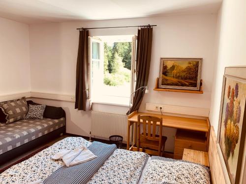 a room with two beds and a desk and a window at Schöneben Apartment Zollhaus 