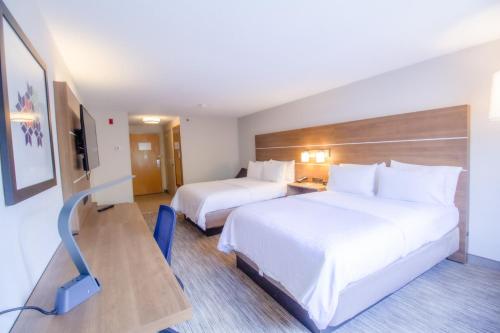 a hotel room with two beds and a desk at Holiday Inn Express & Suites - Lincoln East - White Mountains by IHG in Lincoln