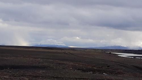 a view of a desert with mountains in the background at Holssel road 864 in Myvatn