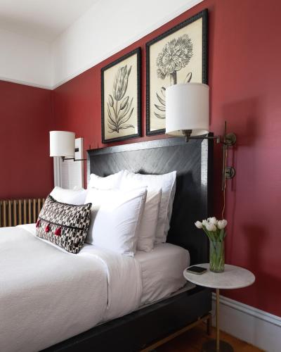 a bedroom with red walls and a bed with white pillows at The Water Street Inn in Kittery