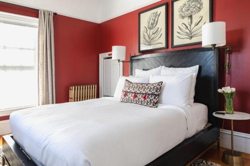 a bedroom with a white bed with red walls at The Water Street Inn in Kittery