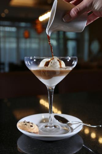 a person pouring a drink into a martini at InterContinental Real Santo Domingo by IHG in Santo Domingo