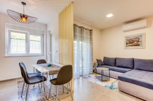 a living room with a couch and a table and chairs at Apartmani Leptir in Rakovica