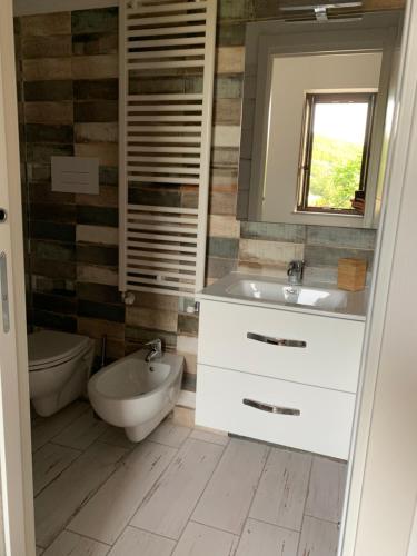 a bathroom with a sink and a toilet and a mirror at Ai Cerri di Remí in Lauria Inferiore