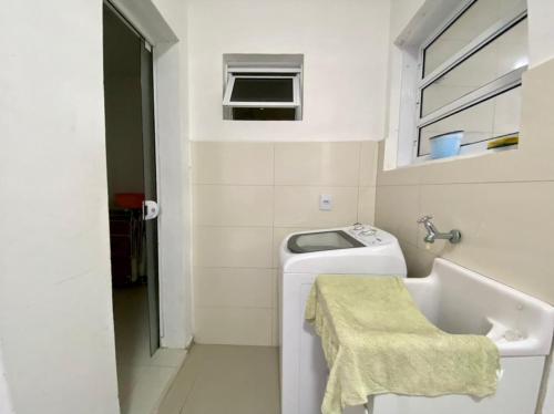 a small bathroom with a sink and a washing machine at Apto Beira Mar 3D in Capão da Canoa
