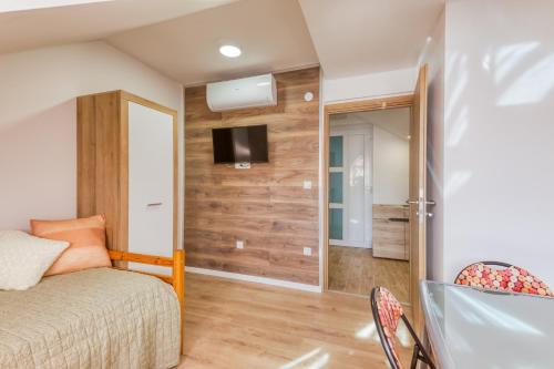 a bedroom with a bed and a tv on a wall at Apartmani Leptir in Rakovica