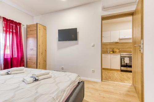 a bedroom with a bed and a kitchen at Apartmani Leptir in Rakovica