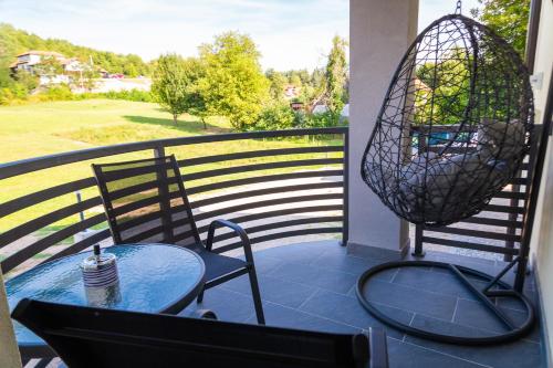 a table and chairs on a balcony with a view at Apartmani Leptir in Rakovica