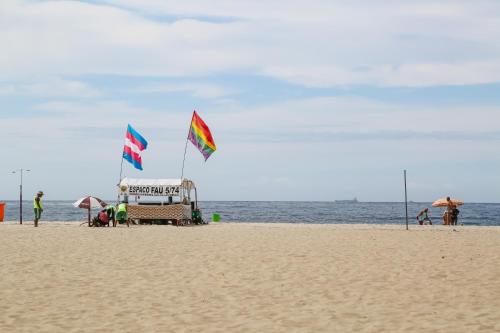 two flags on a sandy beach with the ocean at ibis budget RJ Copacabana in Rio de Janeiro