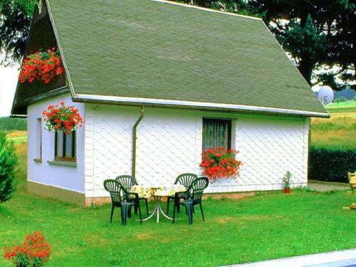 a table and chairs in front of a white house at Holiday Home in Altenfeld with Private Pool in Altenfeld