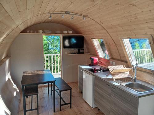 une petite cuisine avec un évier et une table dans l'établissement les insolites du villaret, à Saint-Vincent-les-Forts