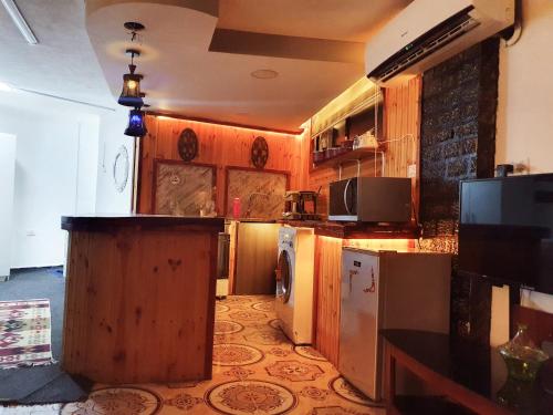 ZEUS apartment في جرش: مطبخ بدولاب خشبي وقمة كونتر