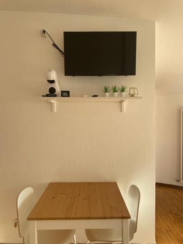ペーロにあるCharming studio next to Fiera with Terrace and parkingのダイニングルーム(テーブル、壁掛けテレビ付)