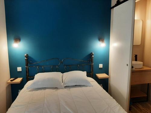 a bedroom with a blue wall and a bed with two pillows at 3 Apt T2 COSY de 40 à 50 M2 Idéal pour un déplacement PRO " Les IRIS " in Bourg-Saint-Andéol