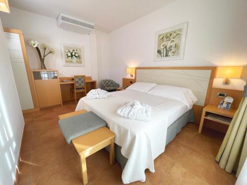 a hotel room with a white bed and a chair at Hotel Domus in Marina di Massa