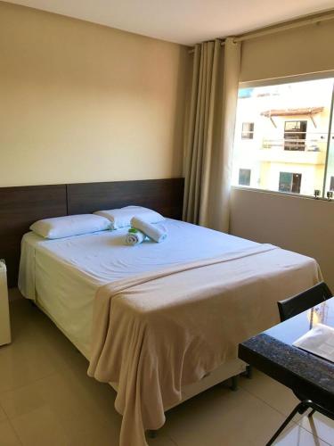 a bedroom with a large bed with a window at Pousada e Restaurante MKE in João Pessoa