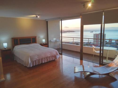 a bedroom with a bed and a view of the ocean at Alluring View at Valparaiso departamento in Valparaíso