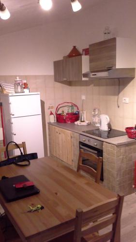 uma cozinha com uma mesa de madeira e um frigorífico branco em Vetralla Terme Viterbo em Vetralla