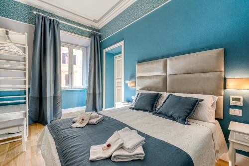 een blauwe slaapkamer met een bed met handdoeken erop bij Rione XXII Apartments in Rome