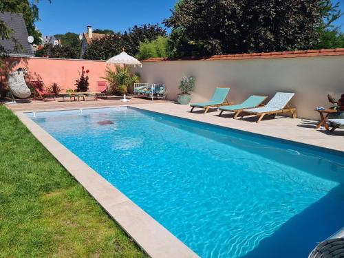 une piscine avec de l'eau bleue dans une cour dans l'établissement le petit boudoir, à Annet-sur-Marne