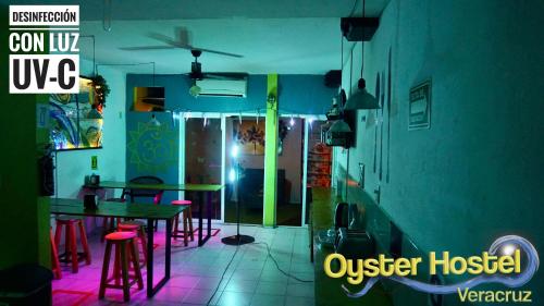 a dining room with a table and red stools at Oyster Hostel in Veracruz