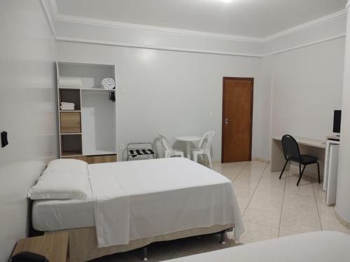 a bedroom with a bed and a table and chairs at Hotel Mais in Macapá