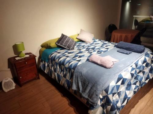a bedroom with a bed with pillows on it at Depto.Barcelona Rucakawi in Temuco