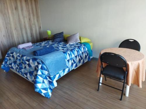 a bedroom with a bed and a table and chairs at Depto.Barcelona Rucakawi in Temuco