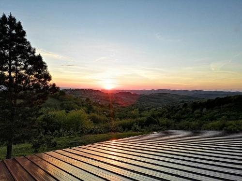 a view of the sunset from a deck with the sun setting at Vikend house in Ljig