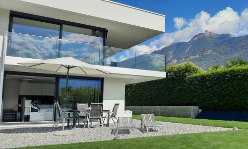 a house with a table and chairs and an umbrella at Alps Spirits - B&B Studio in Fully