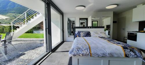 a bedroom with a bed and a large window at Alps Spirits - B&B Studio in Fully