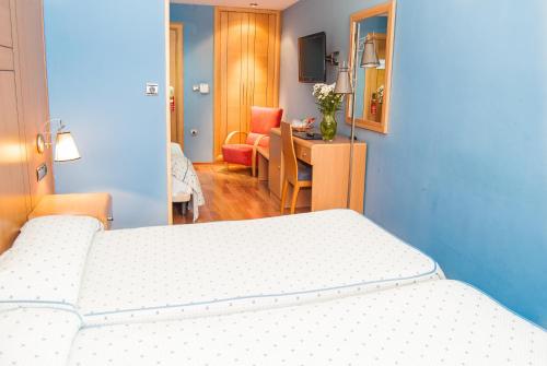 1 dormitorio con 2 camas y sala de estar con escritorio. en Reino de Granada en Granada