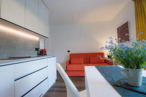 uma cozinha e sala de estar com um sofá laranja em Villa Lucia appartamento Fiore em Padola