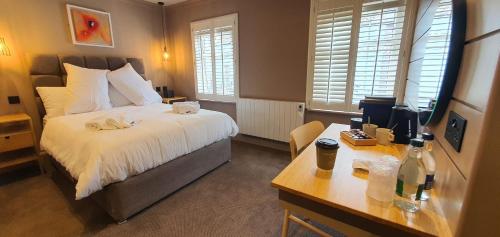a hotel room with two beds and a desk at The Lemon Leaf Café Bar and Townhouse in Kinsale