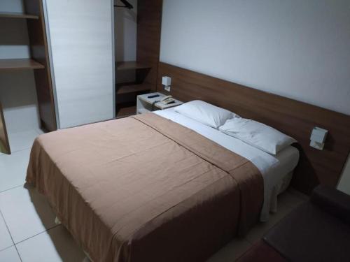 a bedroom with a large bed with a wooden headboard at Flat 427, Imperial Flat Tambau NOBILE in João Pessoa
