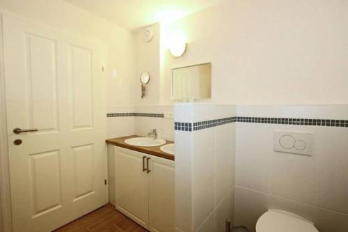 a white bathroom with a toilet and a sink at Appartement Sonnenblick in Fliess