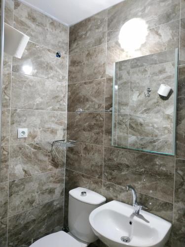 La salle de bains est pourvue de toilettes et d'un lavabo. dans l'établissement Zeytinada Pansiyon ve Gözleme, à Güney