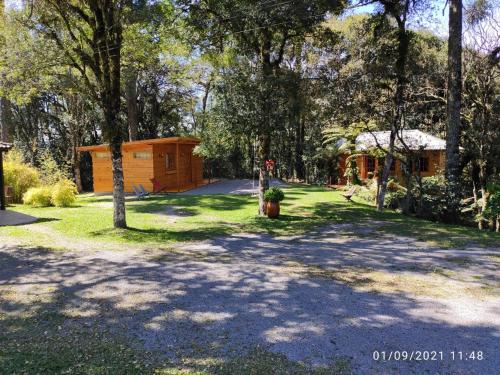ein Haus inmitten eines Gartens mit Bäumen in der Unterkunft Rancho do Xaxim - Gramado in Gramado
