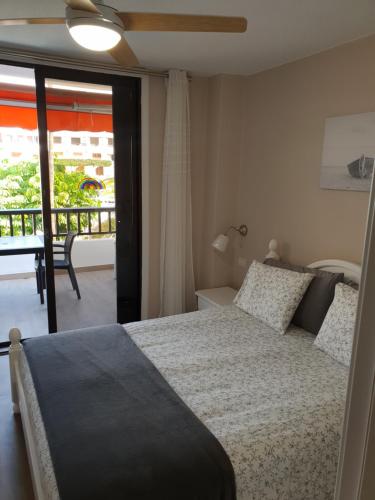 1 dormitorio con cama y vistas a un balcón en Parque Santiago 2, en Playa de las Américas