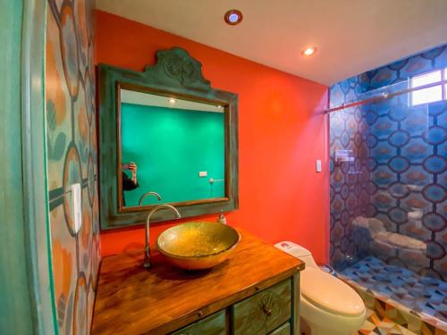 uma casa de banho com um lavatório, um WC e um espelho. em Cosmos Chill - Suite con jacuzzi y acuario em Ambato