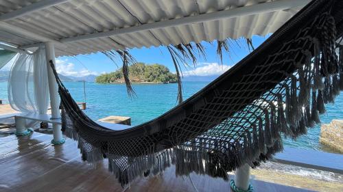 a hammock on a porch with a view of the ocean at Cabana do Mar in Angra dos Reis