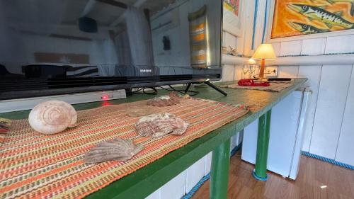 a table with a television and some shells on it at Cabana do Mar in Angra dos Reis