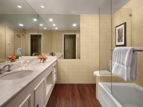 La salle de bains est pourvue d'un lavabo, d'une baignoire et d'une douche. dans l'établissement Little America Hotel & Resort Cheyenne, à Cheyenne