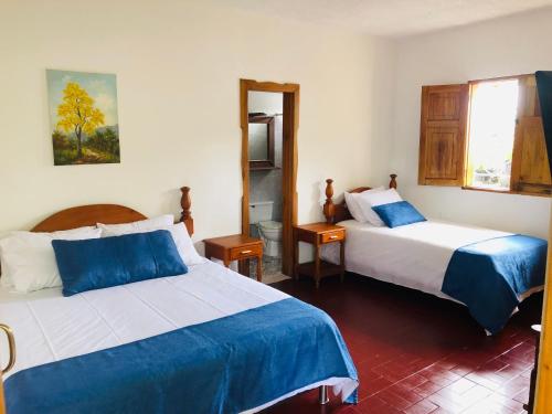 a hotel room with two beds and a mirror at Castillo de Cascadas Finca Hotel in Salamina