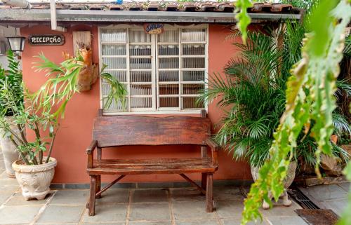an old bench sitting in front of a window at Piccola Pousada in Águas de São Pedro